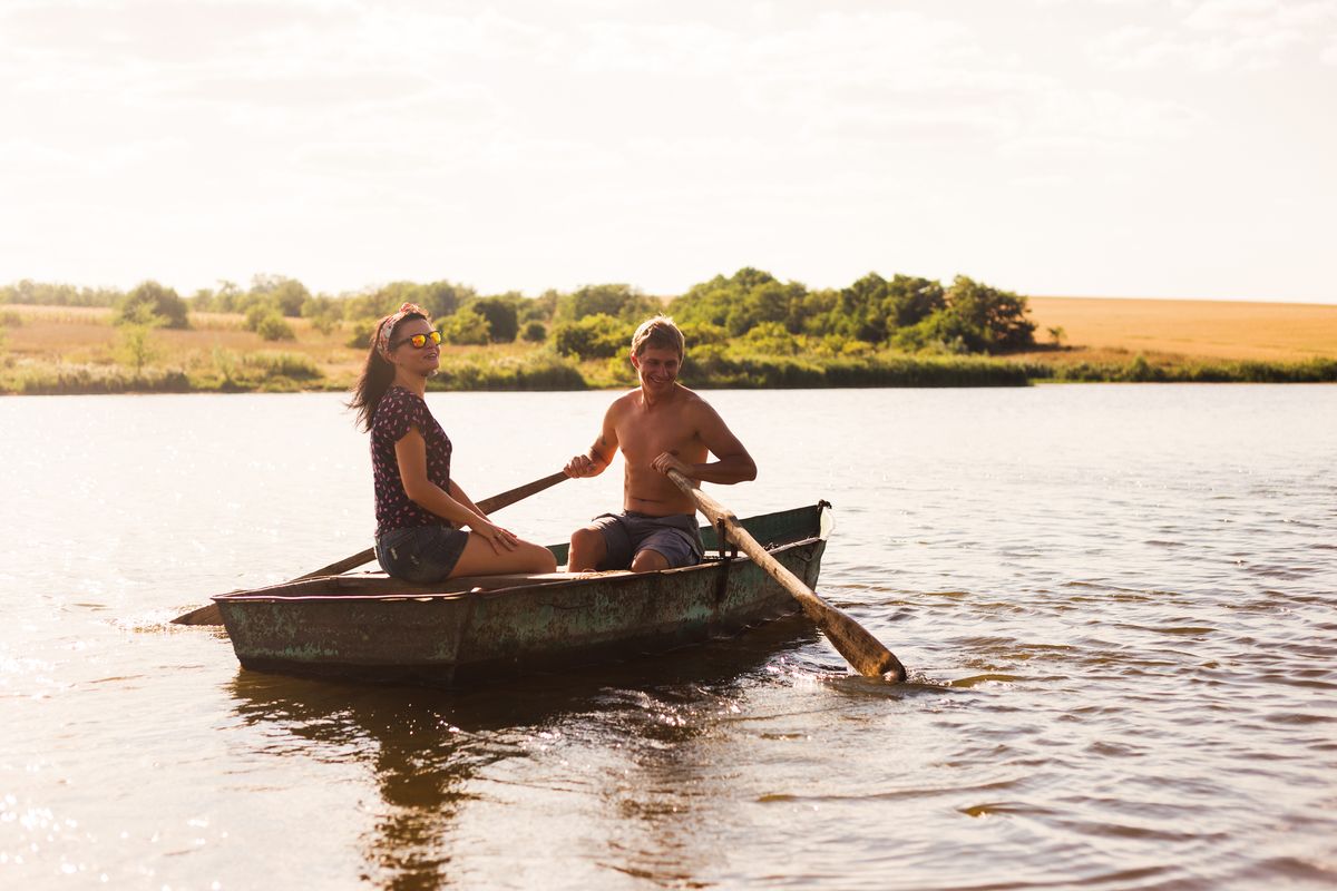 A couple joyfully rowing a boat