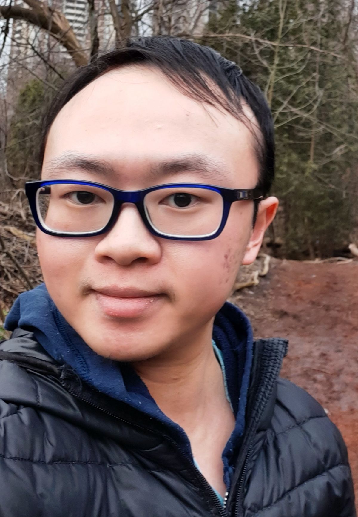 Asian boy with glasses and a black jacket