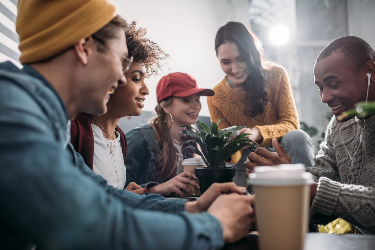 A bunch of happy friends gathered at a coffee shop.